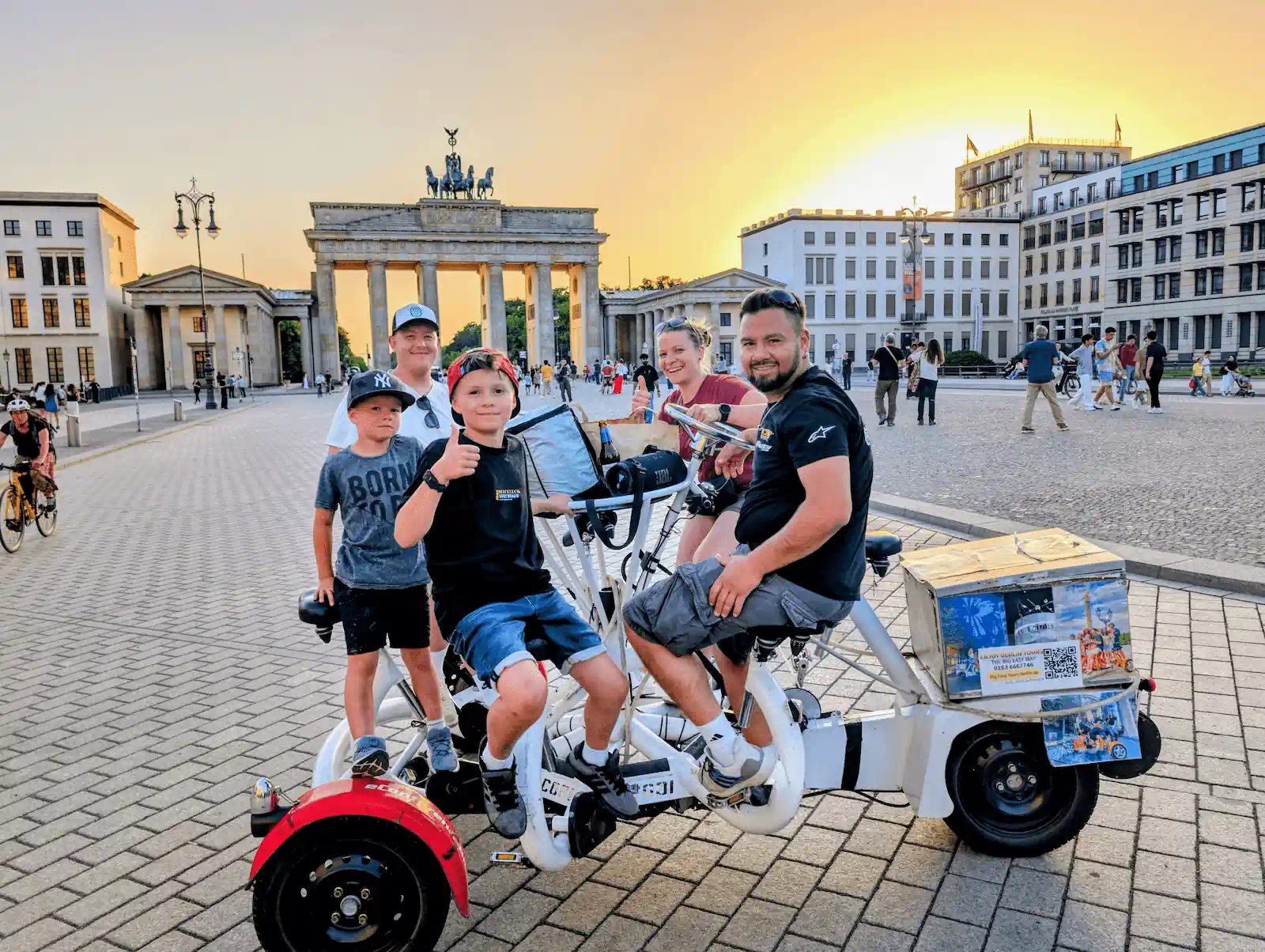 Glückliche Familie auf dem Funbike / Conferencebike vor dem Brandenburger Tor in Berlin